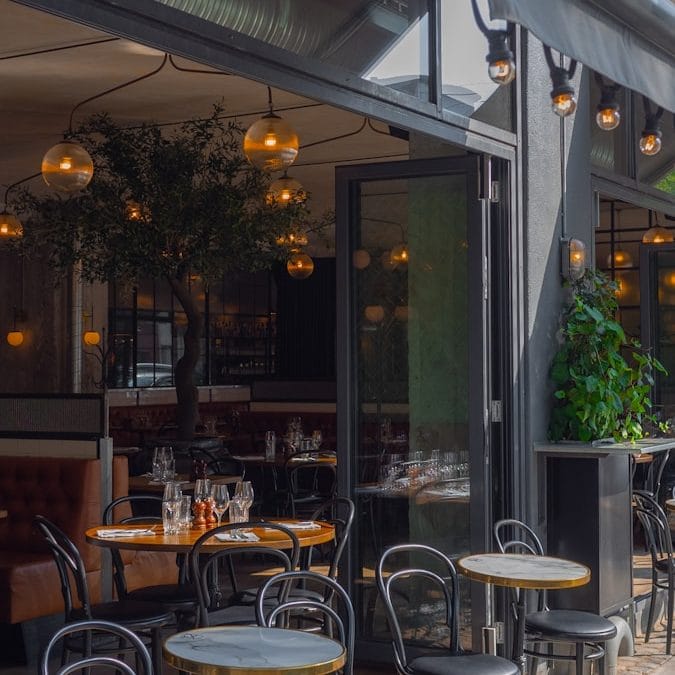 Gemütliche Terrasse mit hängenden Lichtern und Pflanzen